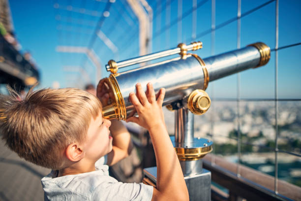istock Little boy looking through coin telescope on the Eiffel Tower 859559462