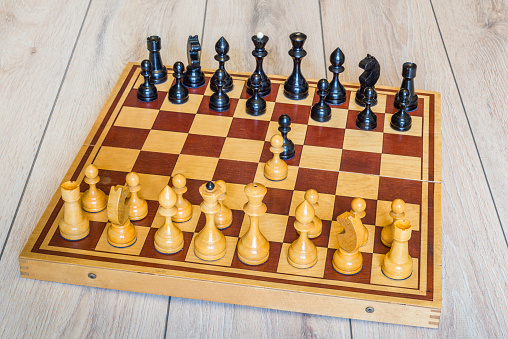 Old chess board with wooden pieces. Beginning of the game