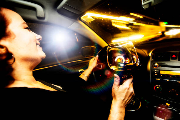 Motor vehicle driver drives a car holding a glass of wine Motor vehicle driver drives a car holding a glass of wine. Drinking and driving is both illegal and dangerous. drunk visual stock pictures, royalty-free photos & images