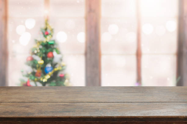 istock Wood table top on blur with bokeh christmas tree background with snowfall - can be used for display or montage your products. 859571572
