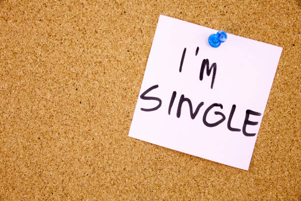 istock Torn note paper attached with blue pin to cork board, good as background or backdrop I am single 859572922