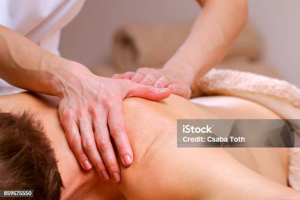 Massage Therapist Massaging Shoulders And Back Of A Male Stock Photo - Download Image Now