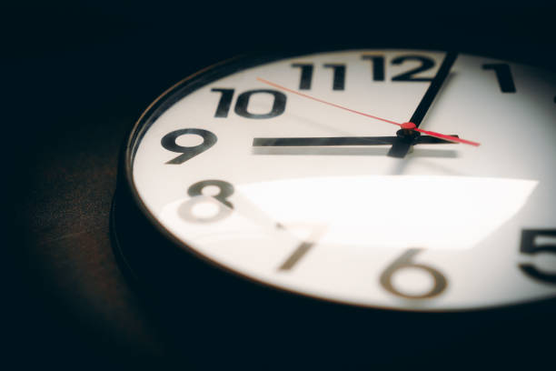 istock Realistic classic dark and white round wall clock, isolated on black background. selective focus. 859575972
