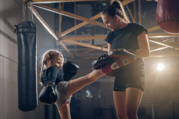 istock Little girl practicing kick boxing with female coach. 859587188