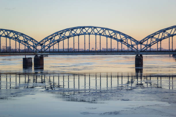 istock Railway bridge over frozen river in snowy winter Riga during sunset 859587240