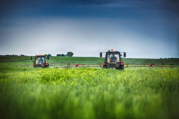 istock Farming tractor plowing and spraying on field 859588300