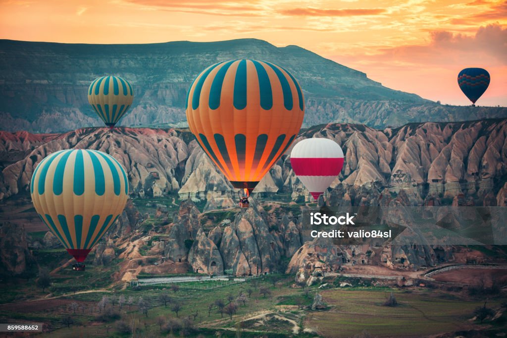 Hot air balloons flying over the valley at Cappadocia, Turkey Hot air balloons flying over the valley at Cappadocia, Turkey. Dramatic Landscape Stock Photo