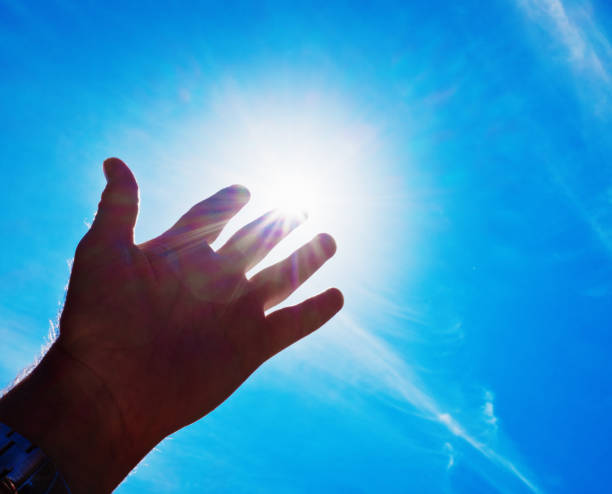 istock Male hand stretched up towards brightly shining sun 859596826