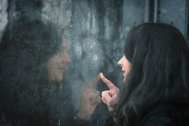 istock Woman and her reflection on rainy window 859600850