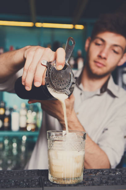 istock Young bartender pouring cocktail drink into glass 859601194