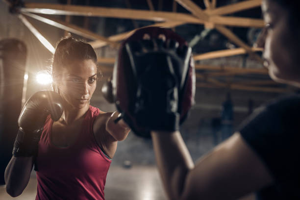determinada fêmea boxer ter treino com um treinador esportivo. - muay thai kickboxing women martial arts - fotografias e filmes do acervo