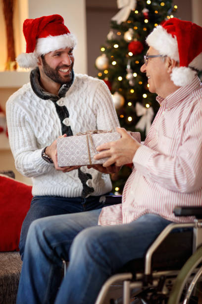 istock sharing gift on Christmas- smiling son giving present to father 859605034