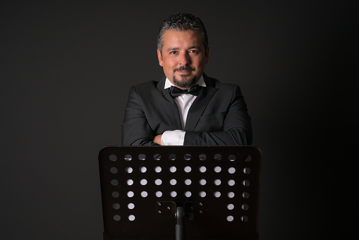 Studio photo of music conductor over black background