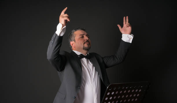 Studio photo of music conductor over black background