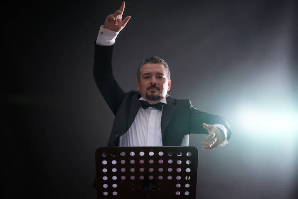 Studio photo of music conductor over black background