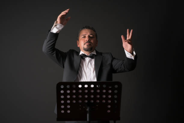 Studio photo of music conductor over black background