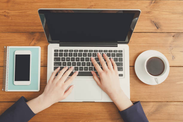 istock Female using laptop in coffee shop, close-up, top view 859611654