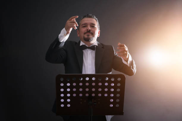Studio photo of music conductor over black background
