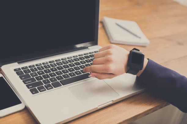 istock Close-up of woman using smart watch at workplace 859612046