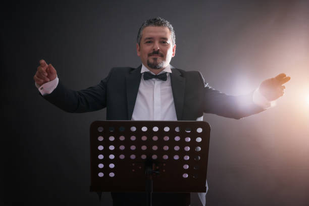 Studio photo of music conductor over black background