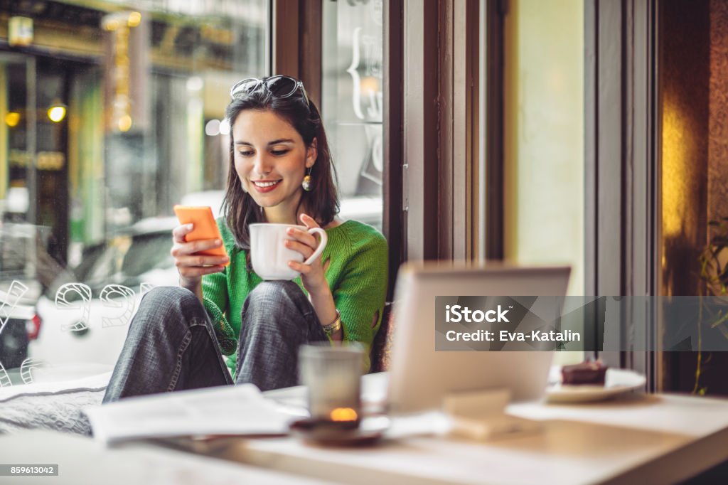 Coffee break Young woman enjoying a cup of coffee on a rainy day Coffee - Drink Stock Photo