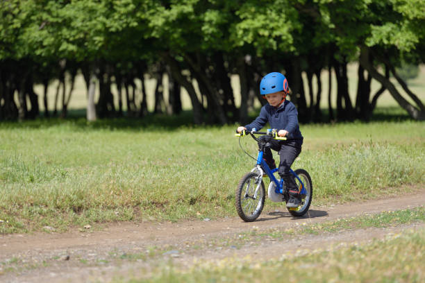 istock Happy kid boy of 5 years having fun in spring forest with a bicycle on beautiful fall day. Active child wearing bike helmet. 859624126