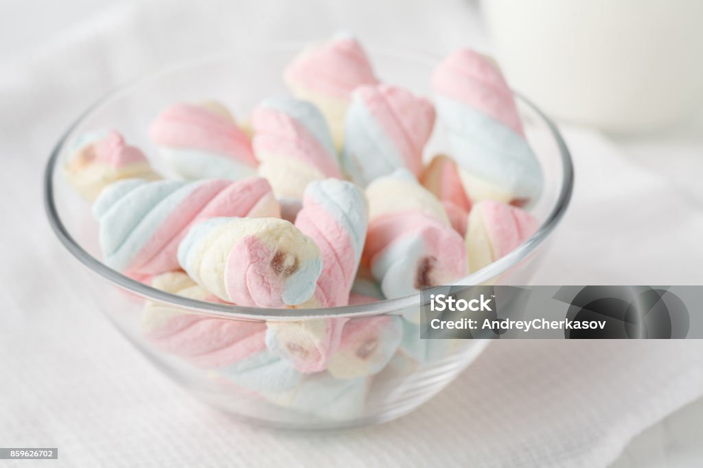 Twisted marshmallows in a cup, over wood background. Bowl Stock Photo