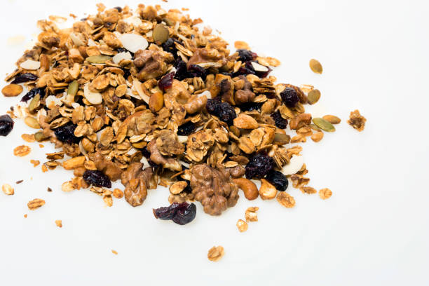istock Homemade granola spilling from bowl on wooden table 859630912