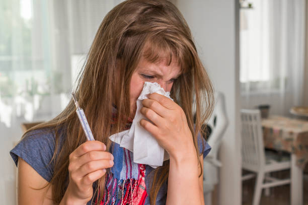 istock Sick woman with flu or cold sneezing into handkerchief 859632834