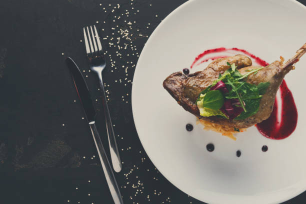 istock Restaurant meals. Duck confit with vegetables on black backgroun 859635464
