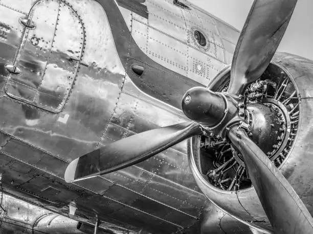 Vintage Douglas DC-3 propeller airplane ready for take off at the runway of an empty airfield. Image with a black and white retro look.