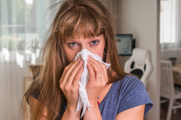 istock Sick woman with flu or cold sneezing into handkerchief 859639174