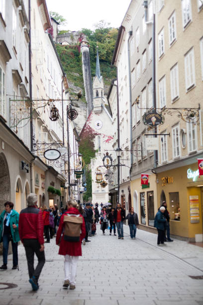 улица getreidegasse с несколькими рекламными знаками, зальцбург - getreidegasse стоковые фото и изображения