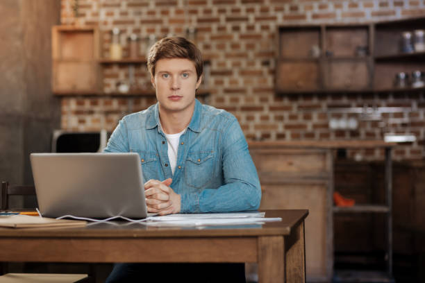 istock Handsome man sitting at the workplace with laptop 859645922