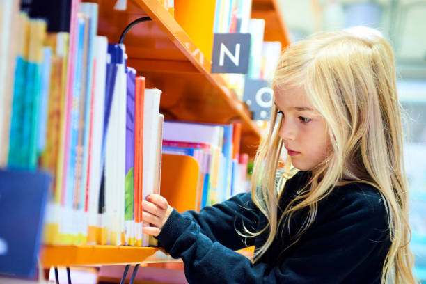 istock Child girl in library 859646048