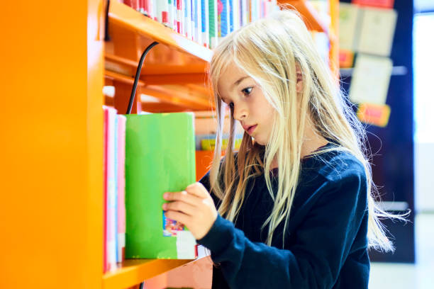istock Child girl in library 859646058