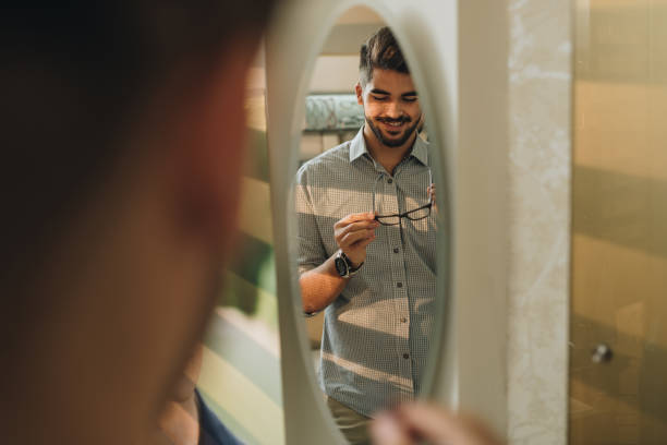 istock Reflection in a mirror of happy man choosing new eyeglasses. 859650148