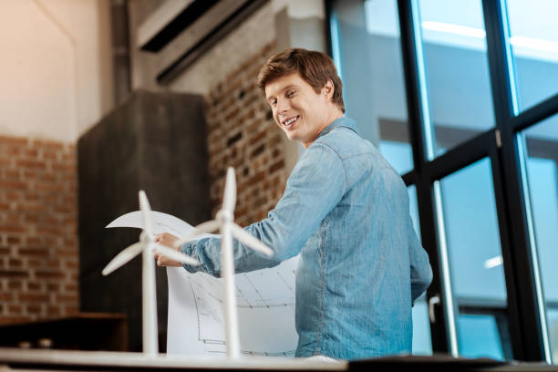 istock Charming man with blueprint looking at wind turbines 859653972