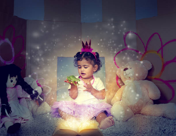 Shot of an adorable little girl sitting on the floor and reading a glowing book
