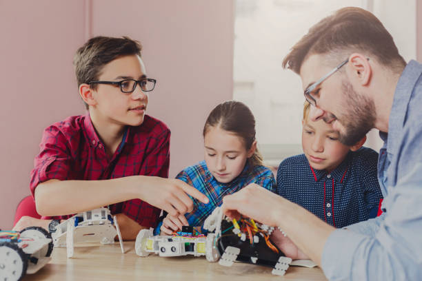 istock Stem education. Kids creating robots with teacher 859655072