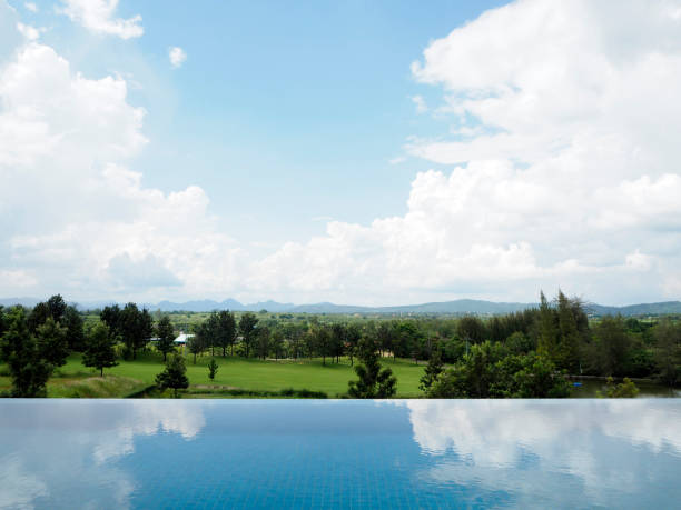 Empty hotel swimming pool on the top of the Mountains. Beautiful private outdoor swimming pool in one luxury spa and wellness center. Many green trees from the mountains in the backgroud. See more images like this in: