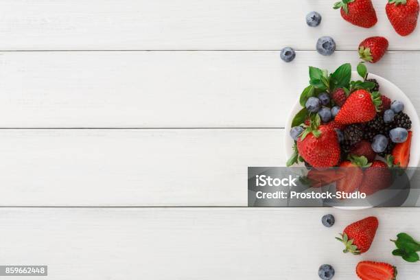 Mixed Berries In Glass Bowls On White Wooden Table Top View Stock Photo - Download Image Now