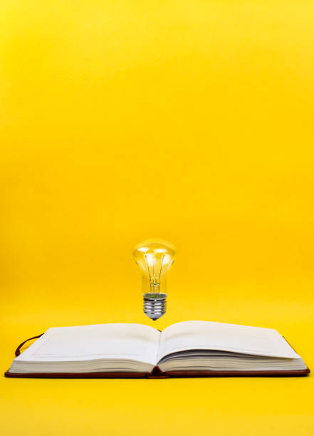 istock Light bulb levitating above the notebook as a concept of new idea, copyspace, yellow background. 859668088