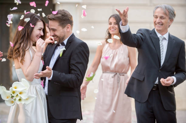 istock Friends throwing petals on wedding couple 859674410