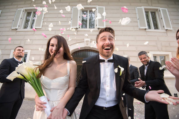 istock Friends throwing petals on wedding couple 859674432