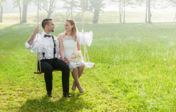 istock Bride and groom sitting in park 859674450