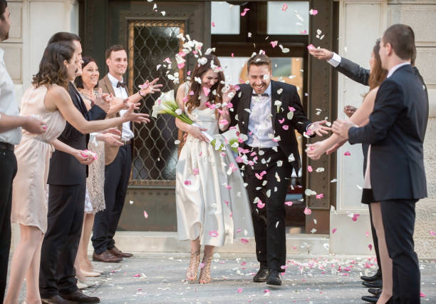 istock Friends throwing petals on wedding couple 859674496