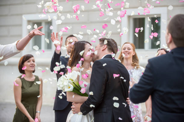 istock Friends throwing petals on wedding couple 859674512