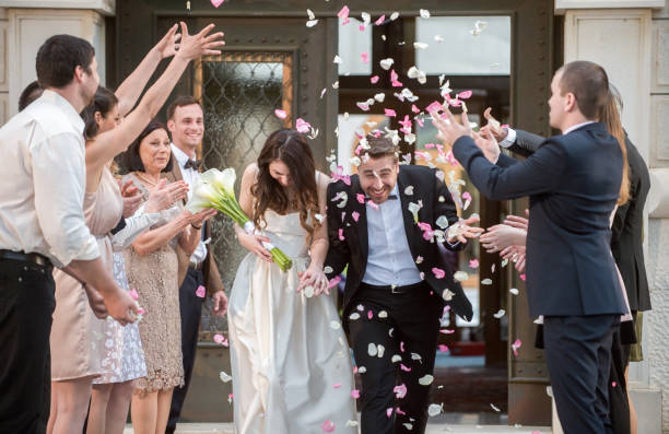 istock Friends throwing petals on wedding couple 859674520