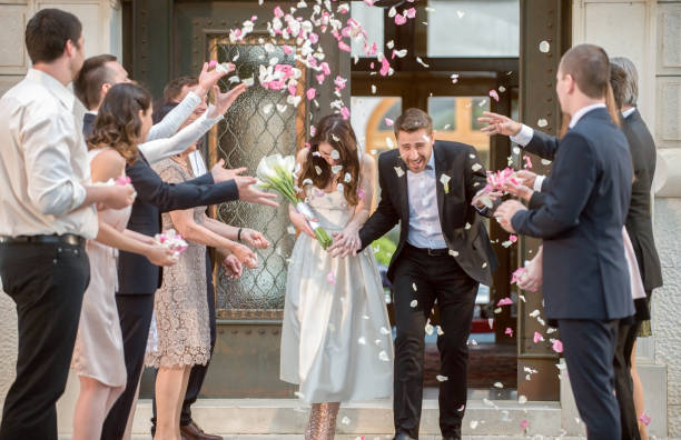 istock Friends throwing petals on wedding couple 859674524